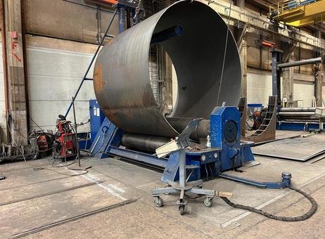 Machine de roulage de tôle en action chez Giga Steel, cintrant une grande tôle en acier pour former une virole