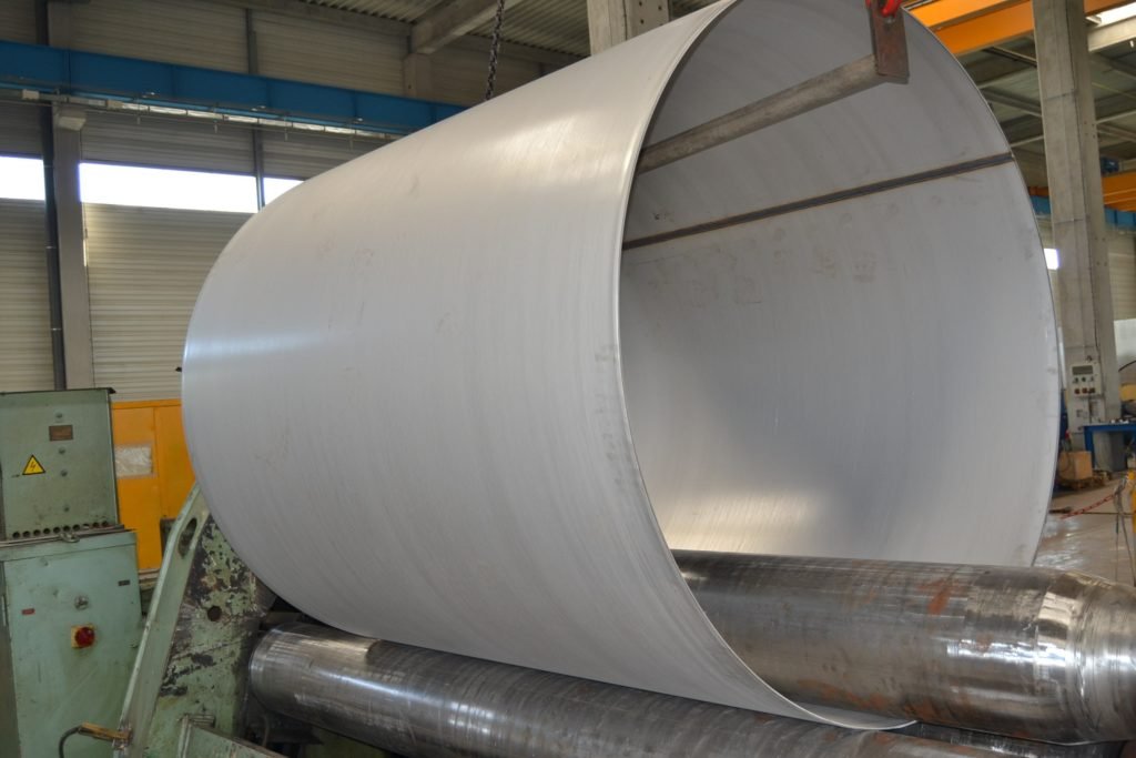 Image montrant le cintrage des tôles chez Giga Steel, avec une tôle métallique courbée pour illustrer le processus de cintrage.