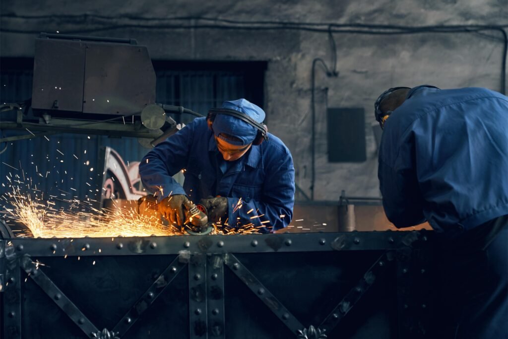 Deux ouvriers en train de travailler sur une structure métallique dans un atelier pour assemblage métallique .