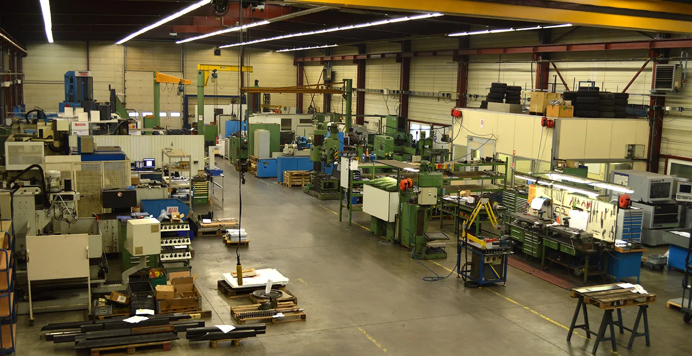 Intérieur d'une usine moderne avec processus automatisés, production optimisée, et chaînes efficaces pour une fabrication mécanique de haute qualité.