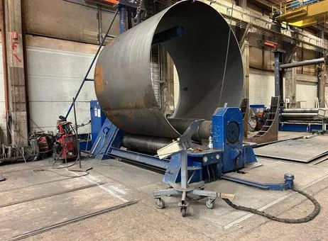 Machine de roulage de tôle en action chez Giga Steel, cintrant une grande tôle en acier pour former une virole