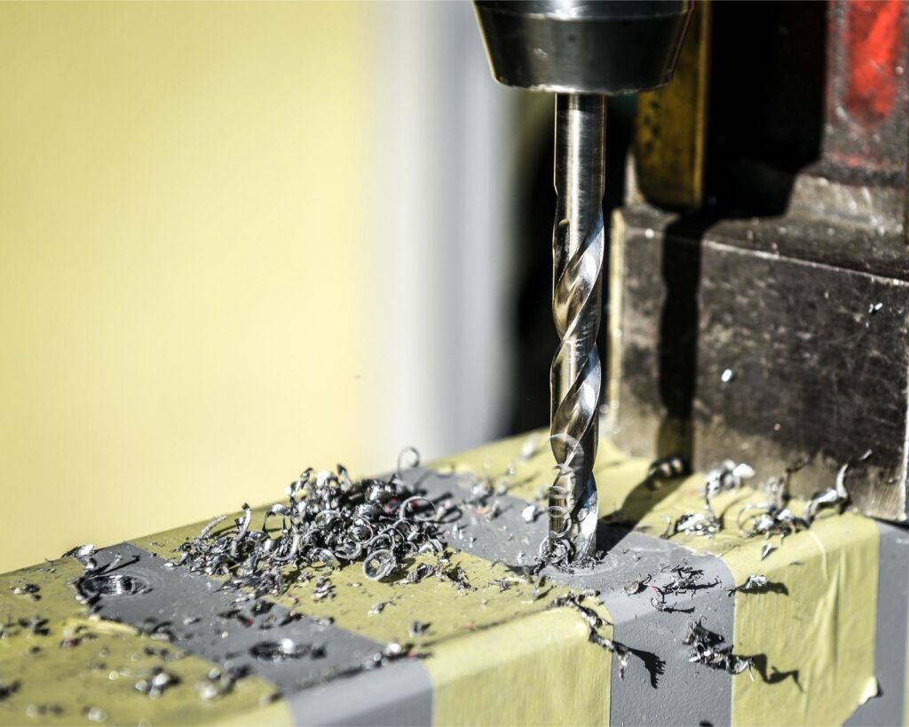 Perceuse CNC usinant des trous précis dans une pièce métallique.