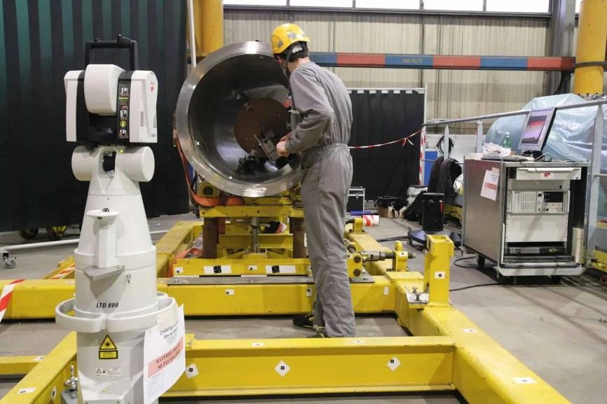 Technicien utilisant un dispositif de métrologie 3D pour le contrôle de précision dans une opération industrielle