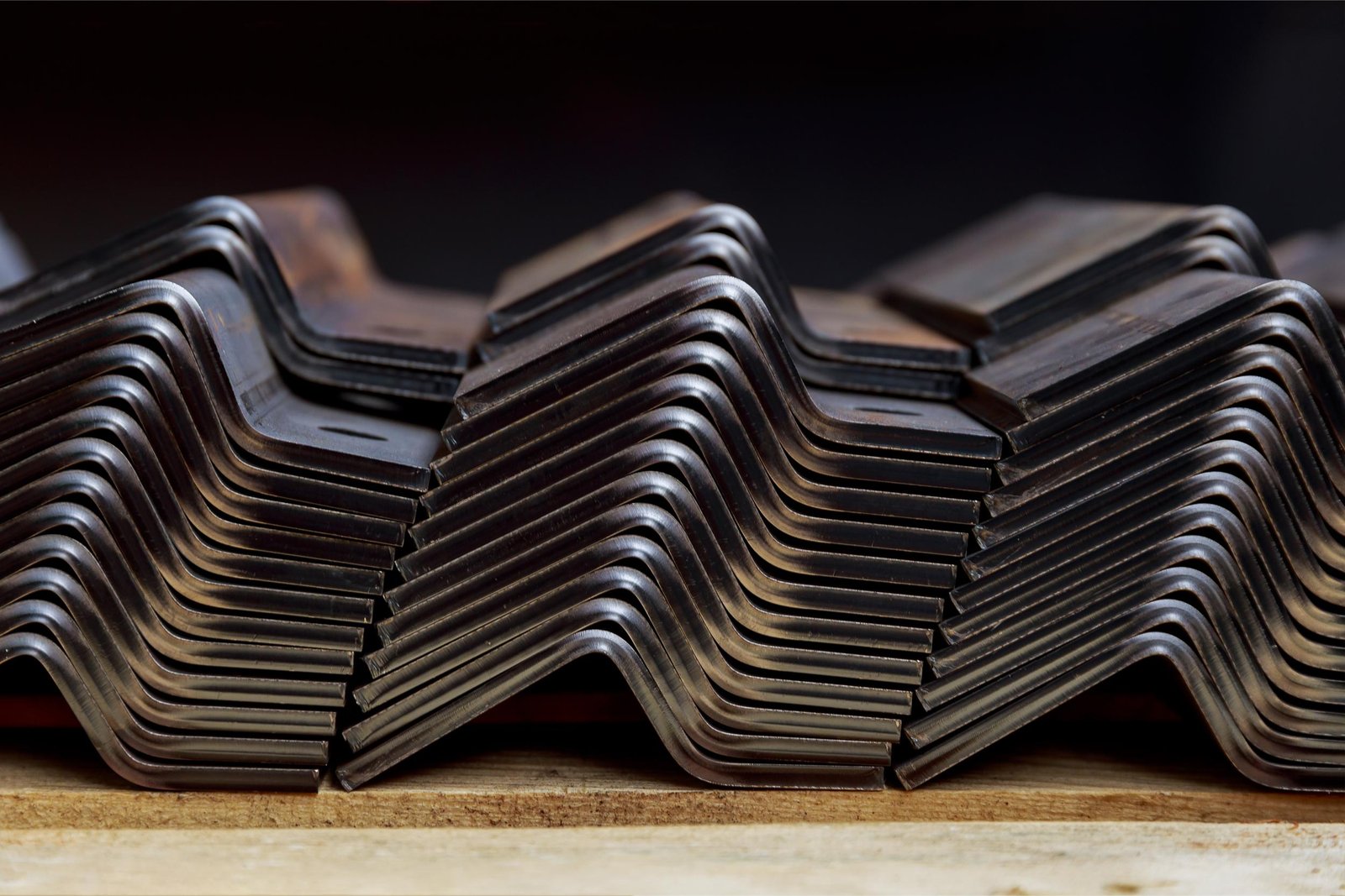 Un complexe industriel de pliage de tôle, montrant des feuilles de métal pliées en formes géométriques complexes, avec un opérateur visible en arrière-plan.