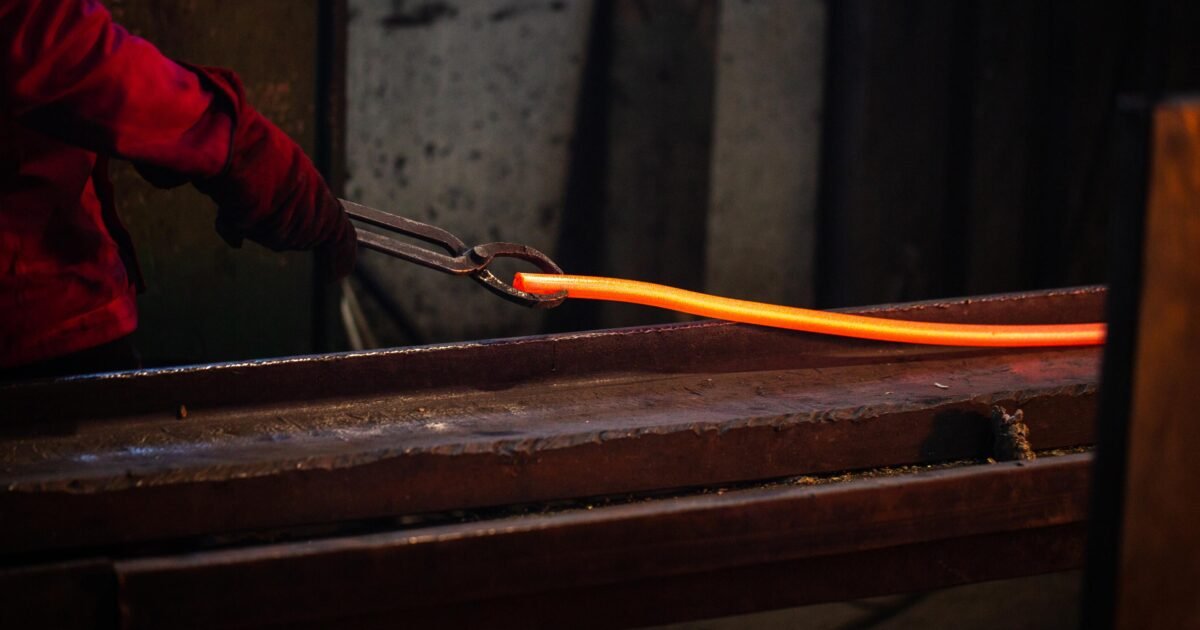 une personne travaillant avec de l'acier fondu, illustrant le formage des métaux.