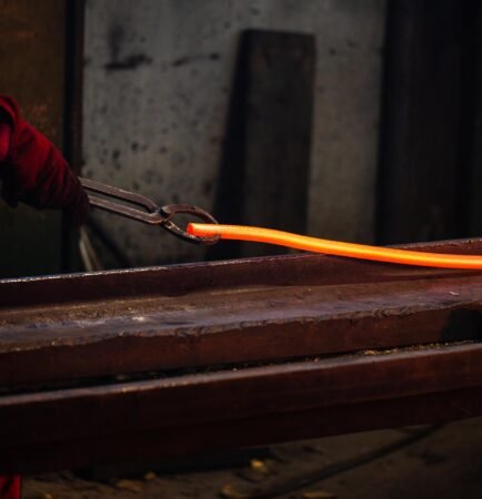 une personne travaillant avec de l'acier fondu, illustrant le formage des métaux.