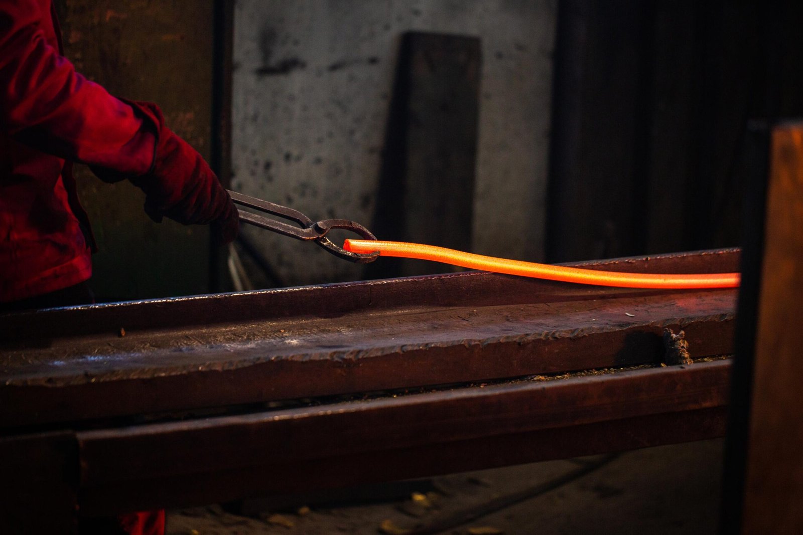 une personne travaillant avec de l'acier fondu, illustrant le formage des métaux.